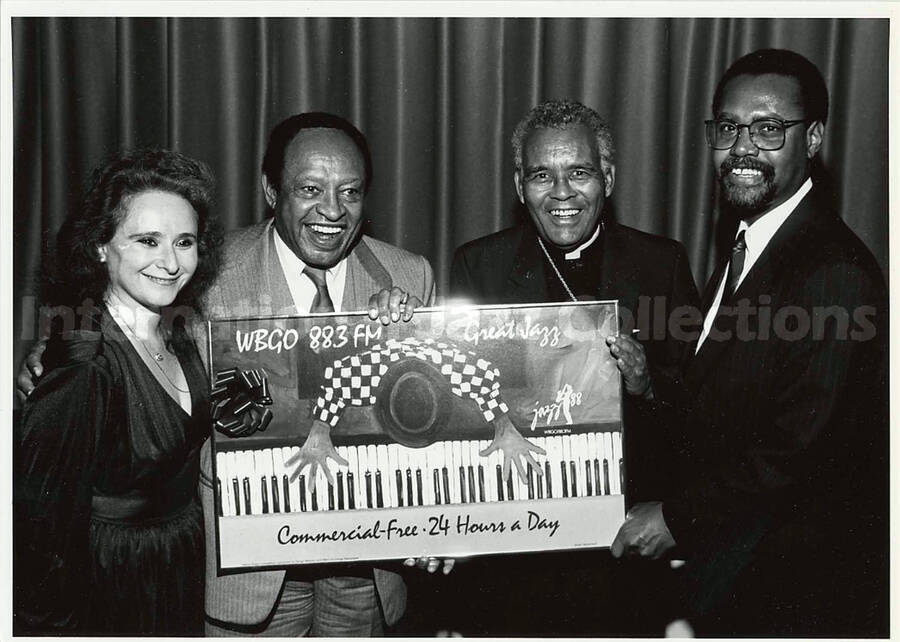 5 x 7 inch photograph. Lionel Hampton with unidentified persons hold a picture that says: WBGO 88.3 FM - Great Jazz - Jazz 88 -Commercial-Free 24 Hours a Day