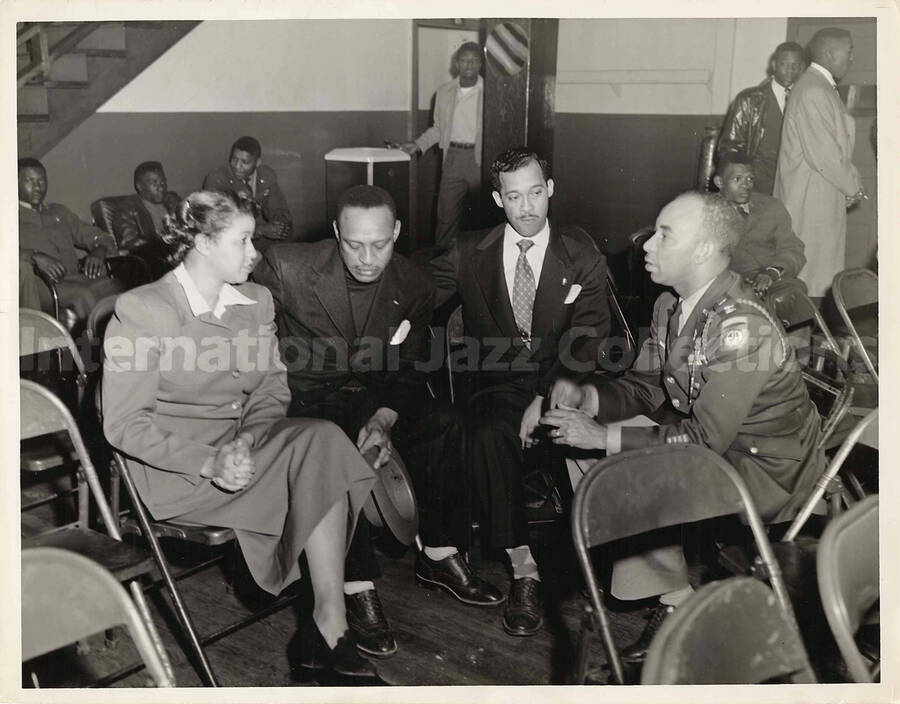 8 x 10 inch photograph. Lionel Hampton with unidentified persons, including a military man. On the man's shoulder is the AA patch of the 82nd Airborne division