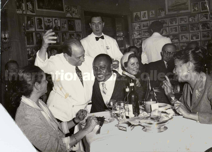 5 x 7 inch photograph. Lionel and Gladys Hampton at the restaurant Alfredo in Rome, Italy. A copy of this photograph was later pasted on the wall of the restaurant alongside others of celebrities. Accompanying this photograph is a portfolio from the restaurant