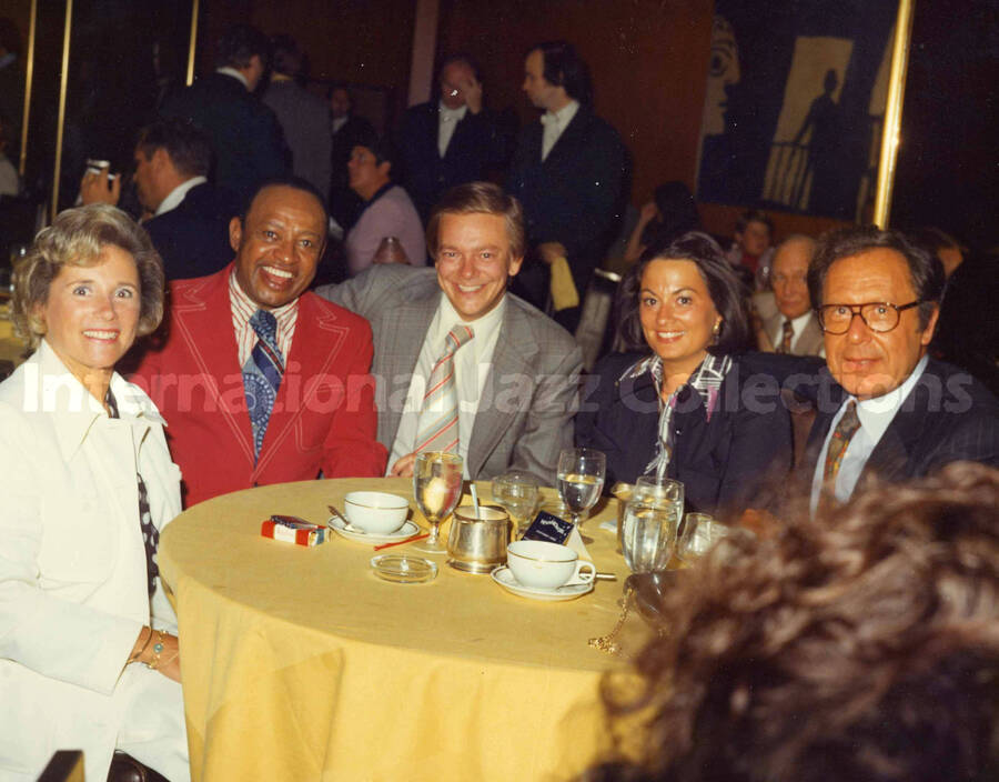 8 x 10 inch photograph. Lionel Hampton with unidentified persons at the Rainbow Grill restaurant