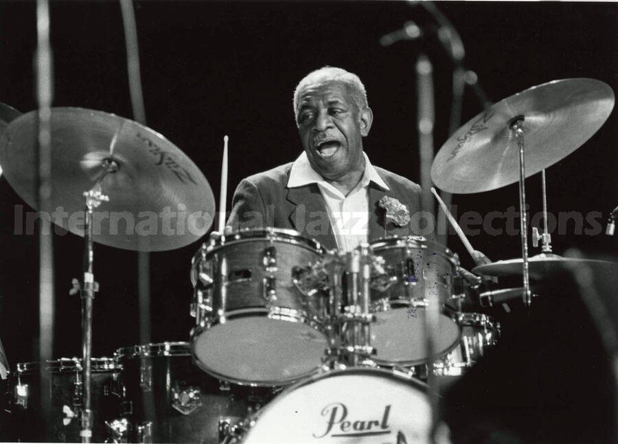 8 x 10 inch photograph. Mickey Roker playing the drums. Stamped on the back of the photograph:University of Idaho; Lionel Hampton/Chevron Jazz Festival