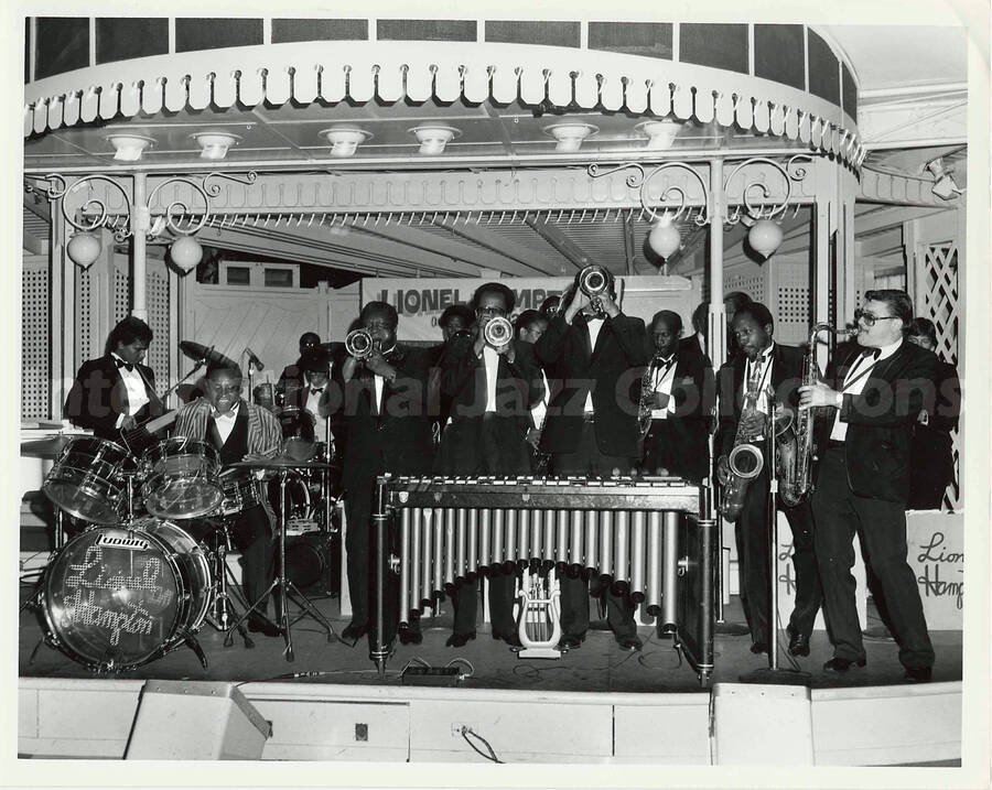 8 x 10 inch photograph. Lionel Hampton performing on the drums with band [at Disneyland?]