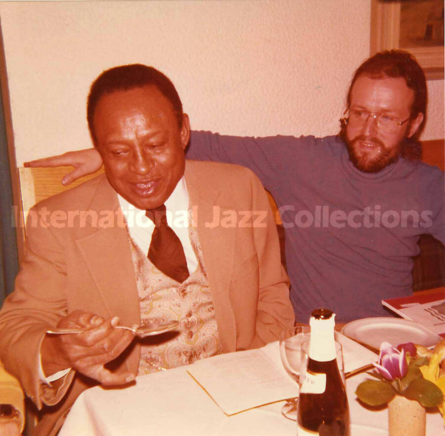 5 x 5 inch photograph. Lionel Hampton and Jean Claude Forestier in a restaurant