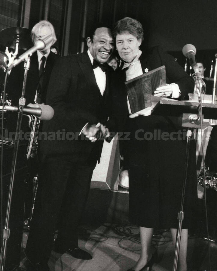 10 x 8 inch photograph. Lionel Hampton receiving from Jeane Jordan Kirkpatrick a plaque from the United States Mission that appointed him as Ambassador of Music to the United Nations