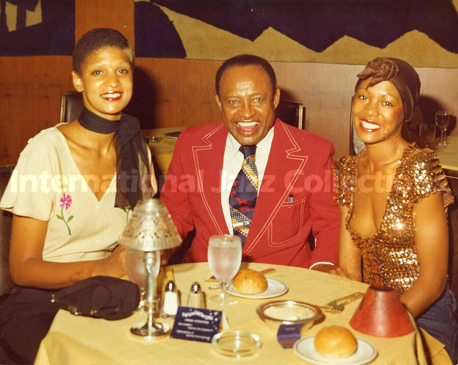 8 x 10 inch photograph. Lionel Hampton with unidentified women at the Rainbow Grill Restaurant