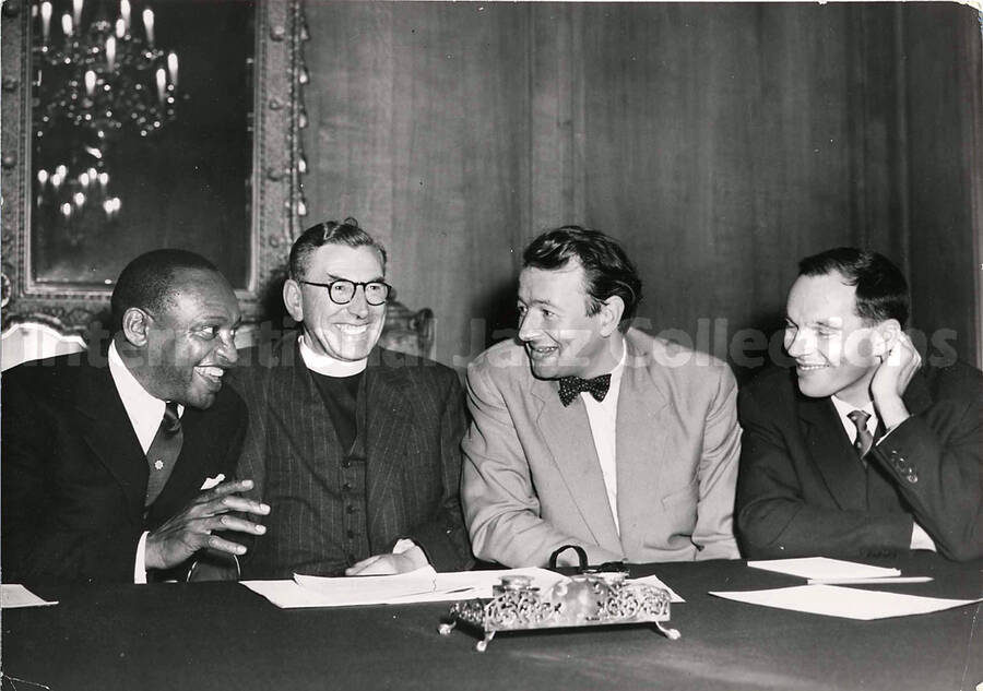 6 x 8 inch photograph. Lionel Hampton with three unidentified men including a religious, [in London, England]