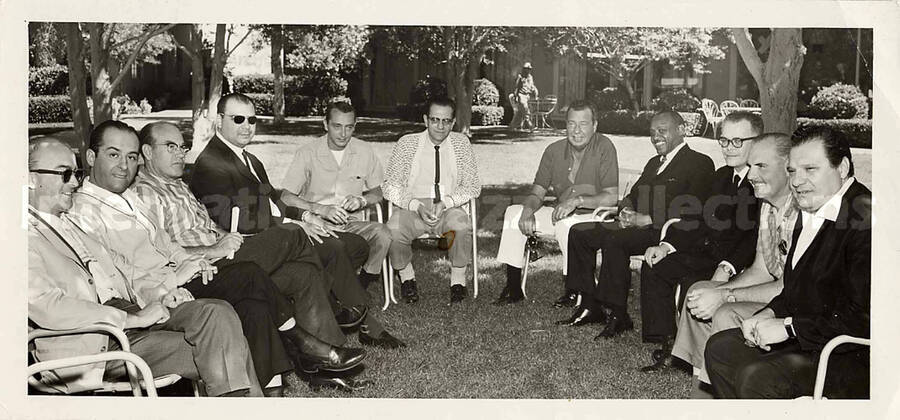 3 1/2 x 7 1/4 inch photograph. Lionel Hampton with a group of unidentified men
