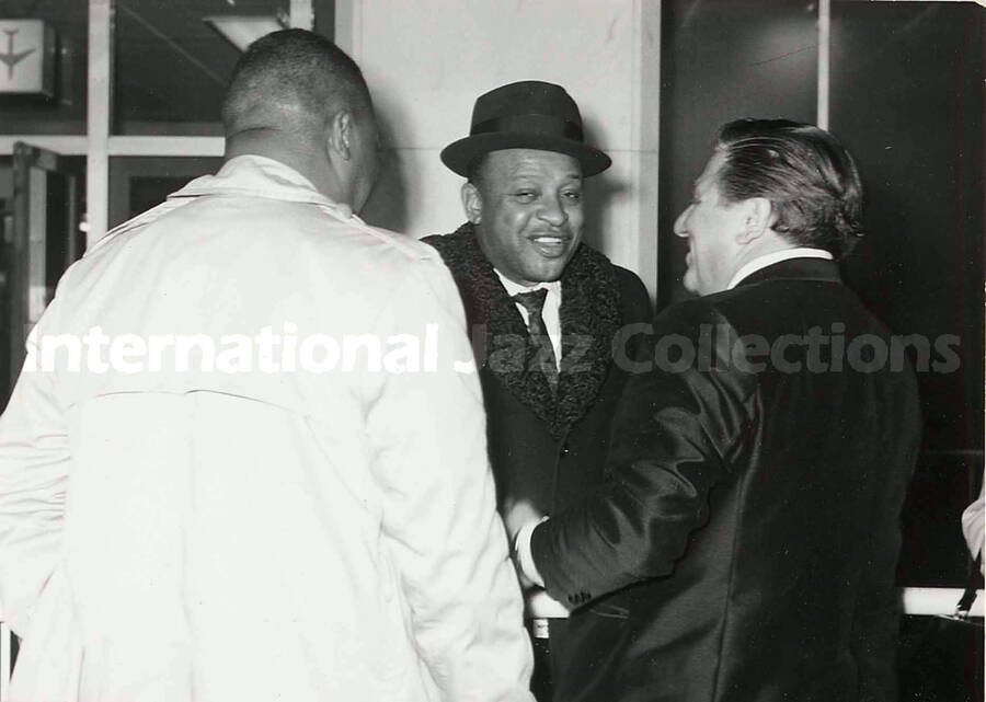4 1/2 x 6 1/2 inch photograph. Lionel Hampton is welcomed in an airport terminal [in Japan]
