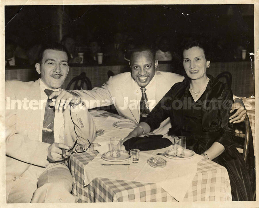 8 x 10 inch photograph. Lionel Hampton with unidentified man and woman in a restaurant