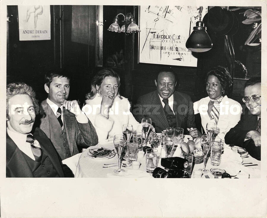 7 x 9 inch photograph. Lionel Hampton having drinks with unidentified persons [abroad?]