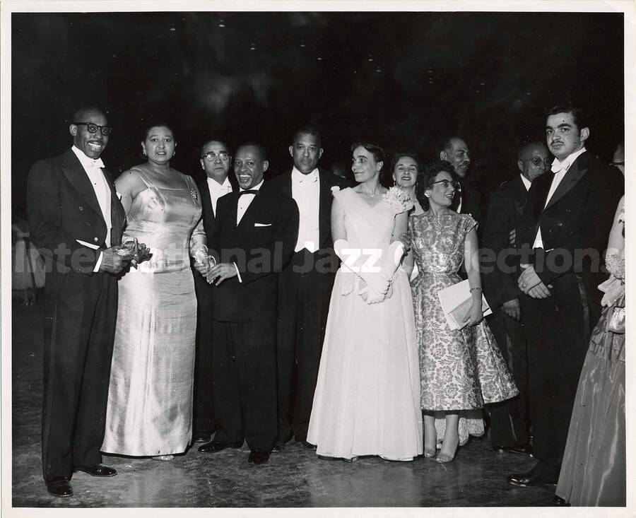 8 x 10 inch photograph. Lionel Hampton posing with unidentified persons [at a ball?]