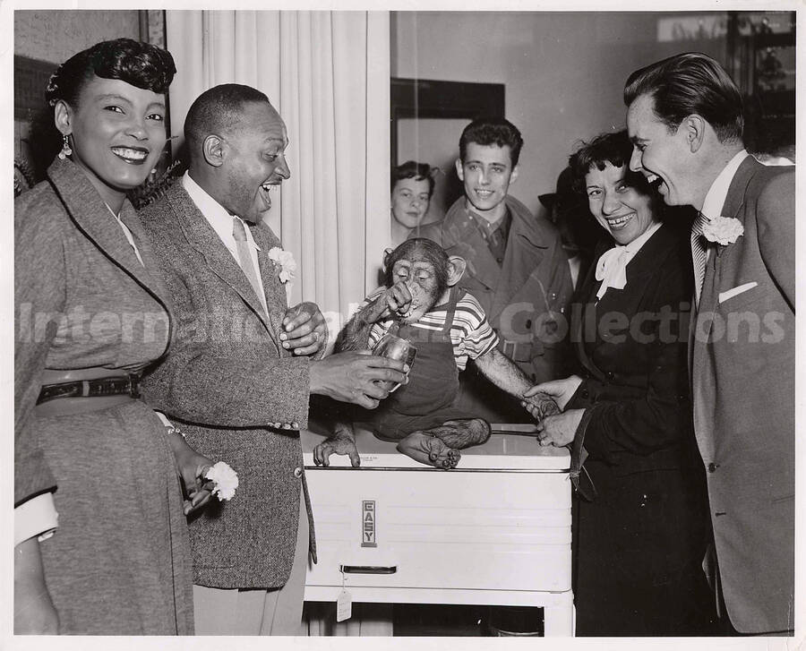 8 x 10 inch photograph. Lionel Hampton with unidentified persons and a monkey