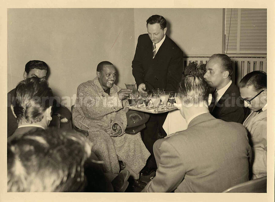 5 x 7 inch photograph. Lionel Hampton having drinks with unidentified persons [abroad?]