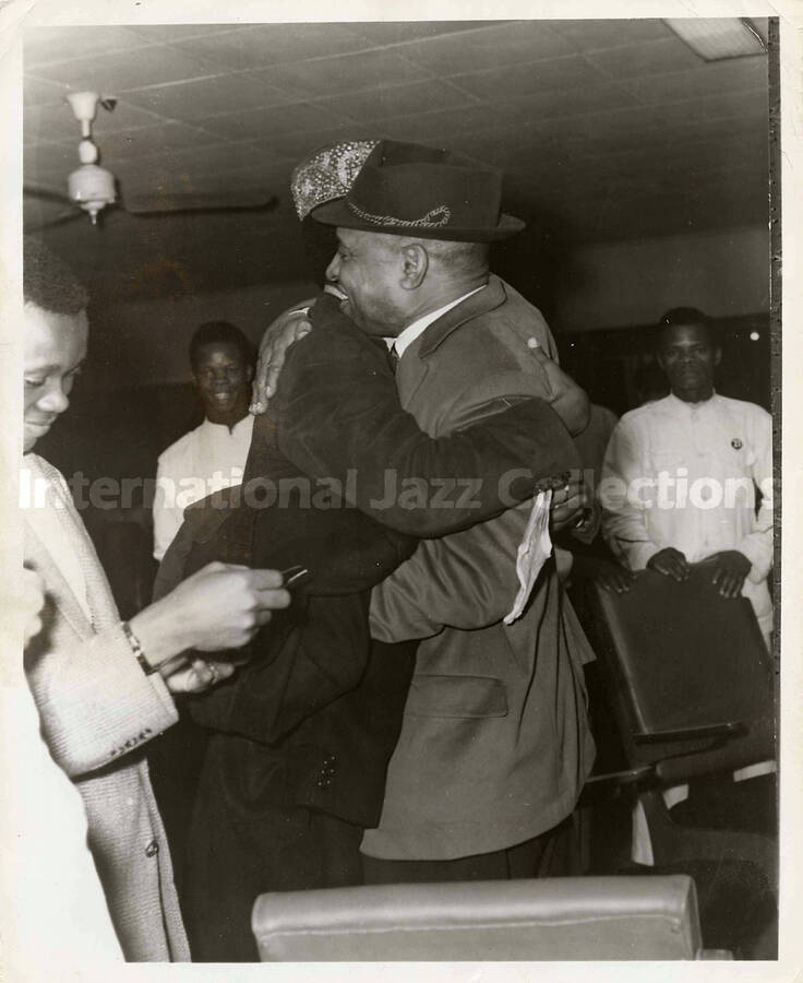 10 x 8 inch photograph. Lionel Hampton is welcomed, probably in an airport terminal of an African country