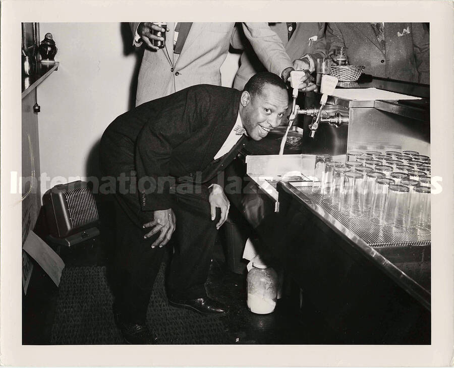 8 x 10 inch photograph. Lionel Hampton at the Altes Brewery. Handwritten on the back of the photograph: In the tap-room of the Altes Brewing Company's guest house