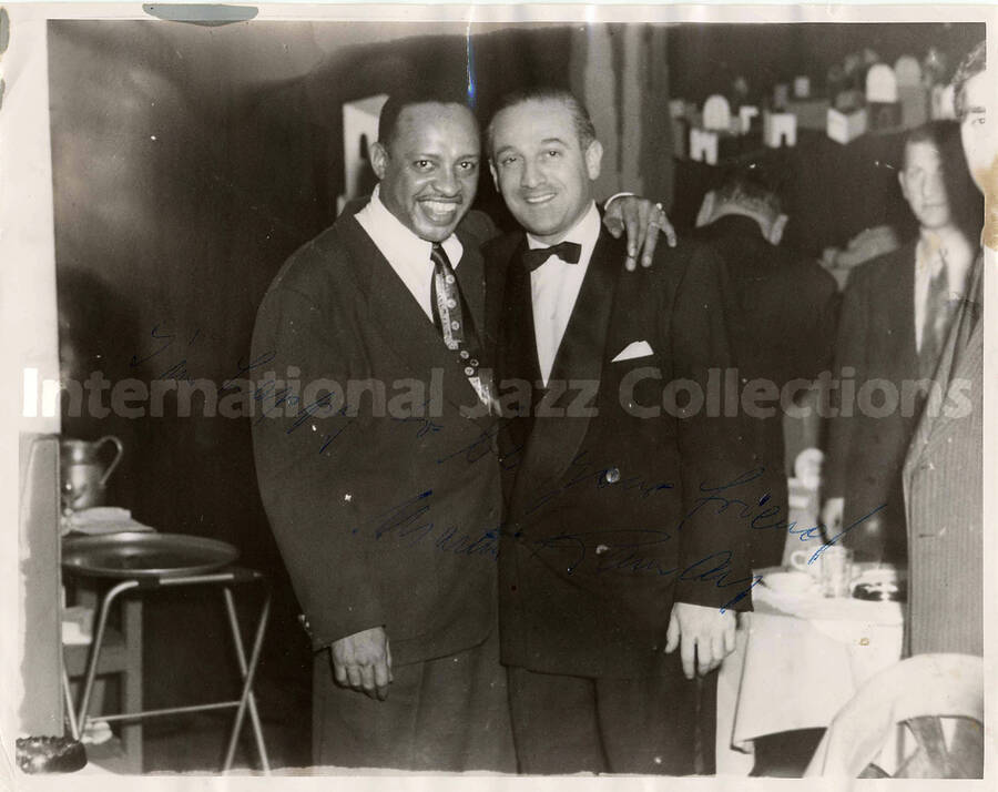 8 x 10 inch photograph. Lionel Hampton with unidentified man in a restaurant. This photograph is dedicated to Lionel Hampton from Martin Ramà?