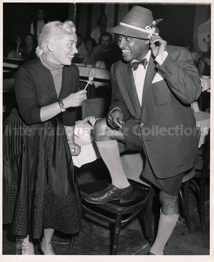 10 x 8 inch photograph. Lionel Hampton with unidentified woman, in a restaurant