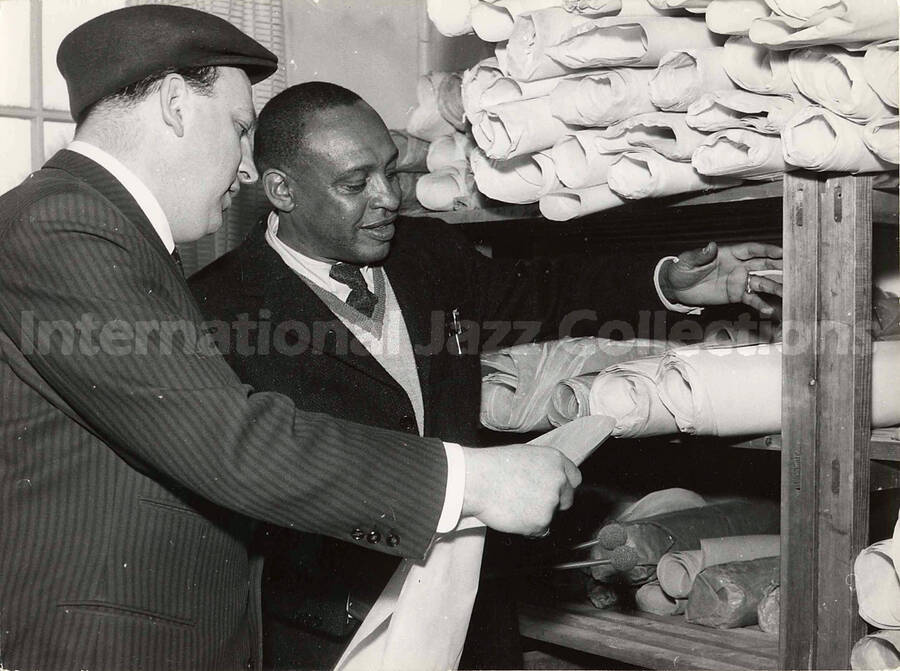 6 1/4 x 8 1/2 inch photograph. Lionel Hampton with unidentified man [in a work shop, in Germany]