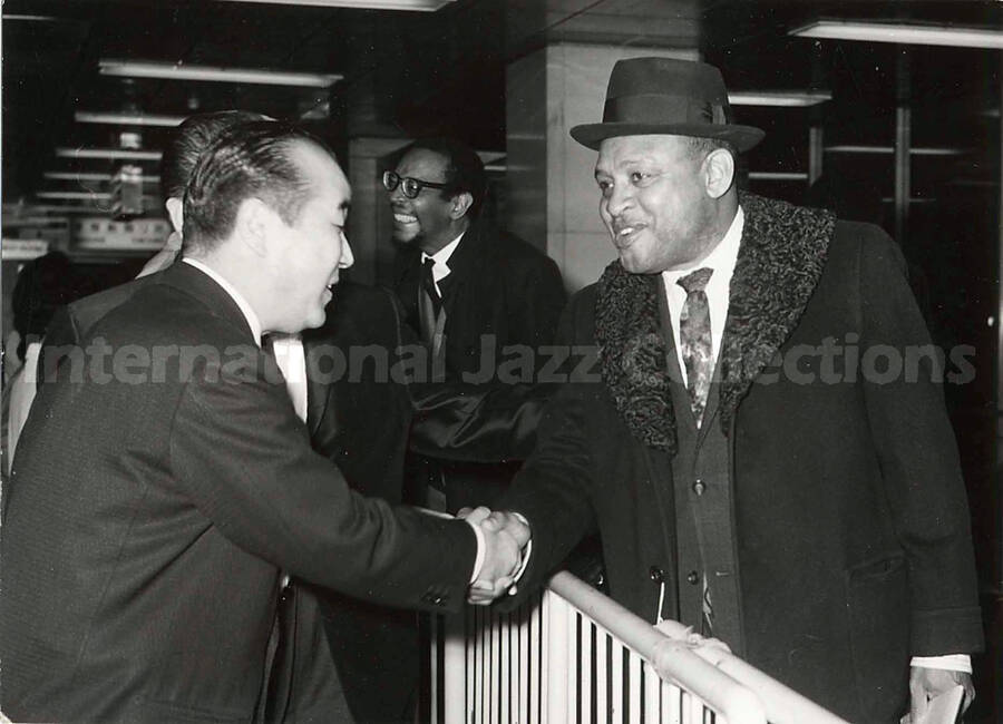 4 1/2 x 6 1/2 inch photograph. Lionel Hampton is welcomed in an airport terminal [in Japan]