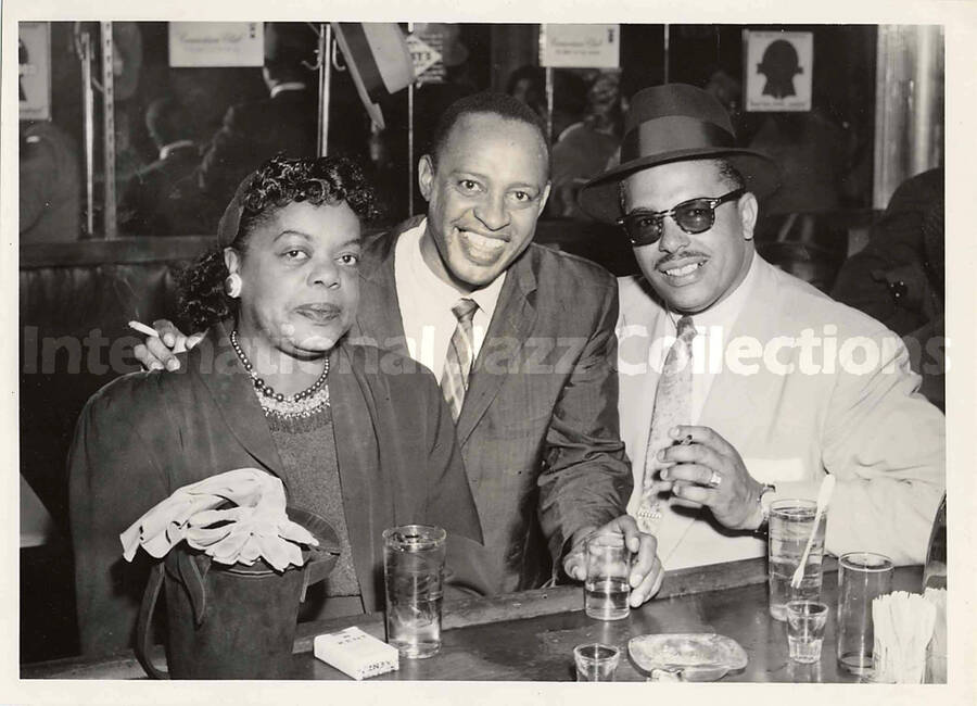 5 x 7 inch photograph. Lionel Hampton with unidentified woman and a man in a tavern
