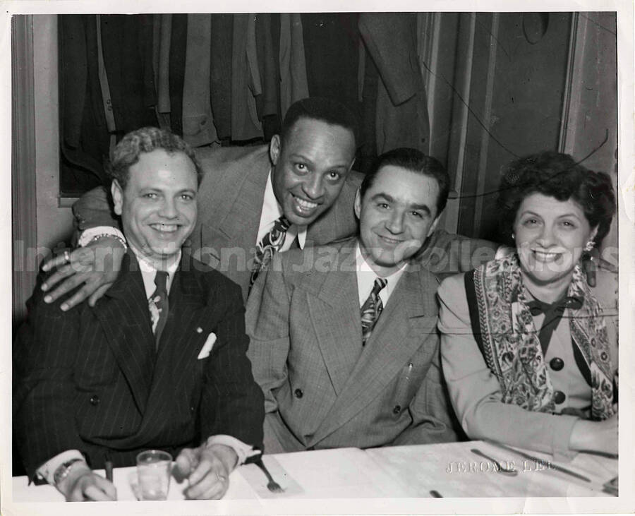 8 x 10 inch photograph. Lionel Hampton with two unidentified men and a woman in a restaurant