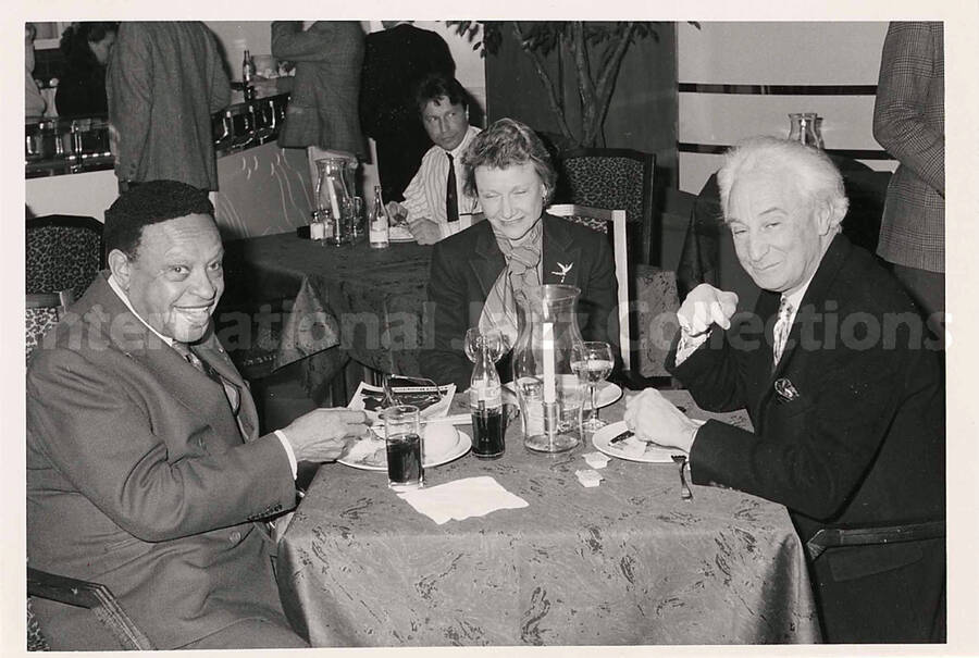5 x 7 inch photograph. Lionel Hampton, Bill Titone, and unidentified woman in a restaurant, [in Sweden]
