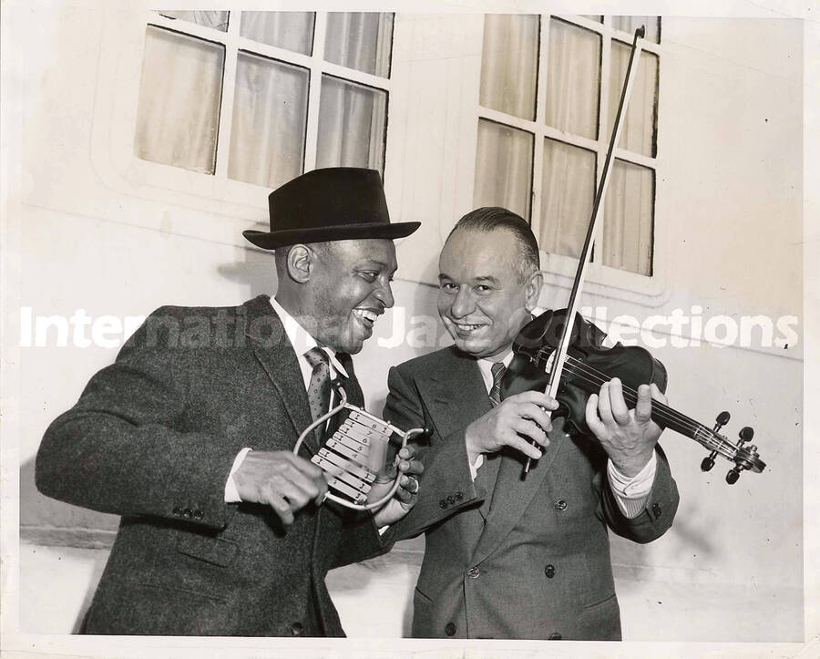 8 x 10 inch photograph. Lionel Hampton playing a mini vibe with unidentified man playing the violin