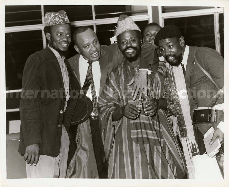 8 x 10 inch photograph. Lionel Hampton with unidentified men, probably in an airport terminal of an African country