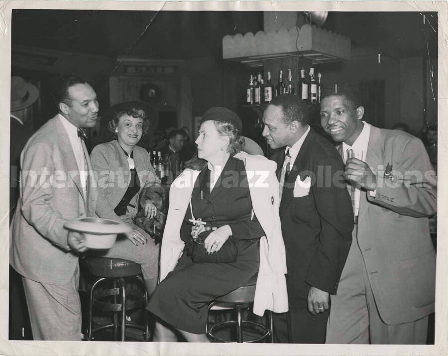8 x 10 inch photograph. Lionel Hampton with unidentified persons in a tavern