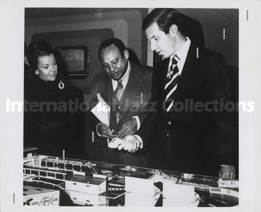 8 x 10 inch photograph. Lionel Hampton observes a demonstration of the Aurora AFX racing game [at the Aurora Super Fair' 74]