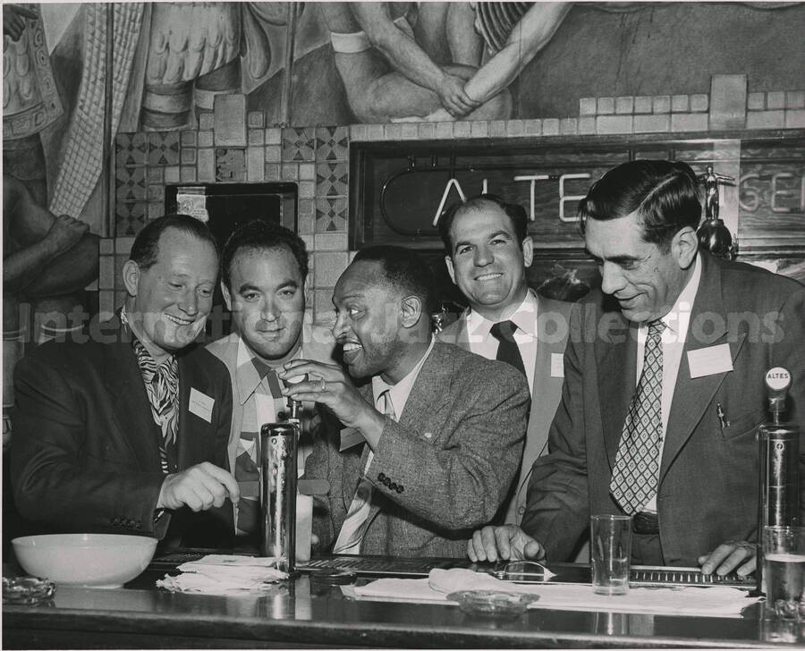 8 x 10 inch photograph. Lionel Hampton with four unidentified men at the tap room of the Altes Brewery, in Logan Heights, San Diego, CA. A sign on the wall reads: Altes Lager Beer
