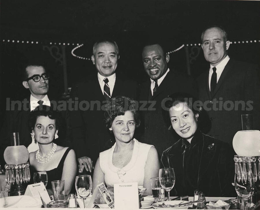8 x 10 inch photograph. Lionel Hampton with unidentified people. Place cards on the dinner table reads: Riverboat; Rise to the occasion