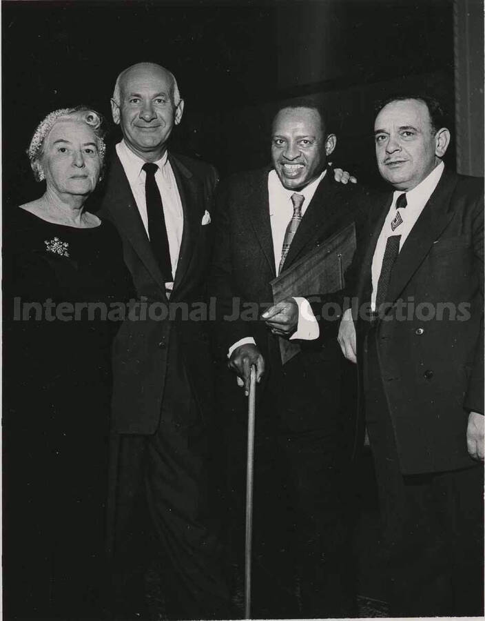 5 x 3 1/2 inch photograph. Lionel Hampton holding a plaque poses with members of the Los Angeles Chapter of Hadassah, on the occasion of his being awarded the certificate of the Hadassah Vocational Education Scholarship for his devotion to the State of Israel. Los Angeles, CA
