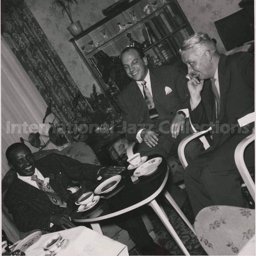 7 x 7 inch photograph. Lionel Hampton with two unidentified men, [in Germany?]