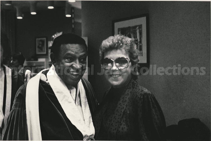 8 x 10 inch photograph. Lionel Hampton with a medal on his neck poses with unidentified woman