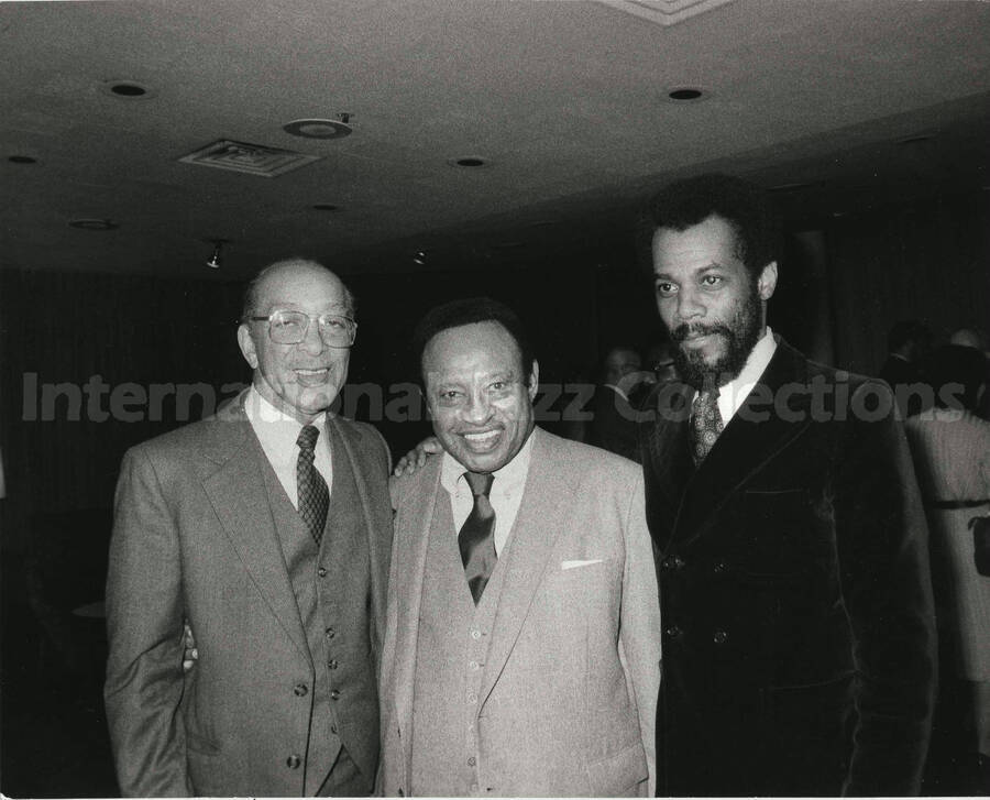 8 x 10 inch photograph. Lionel Hampton with two unidentified men, on the occasion of his receiving a plaque from the United States Mission that appointed him as Ambassador of Music to the United Nations