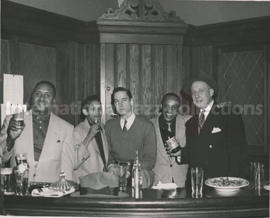 8 x 10 inch photograph. Lionel Hampton with unidentified persons in a tavern
