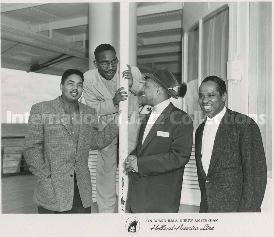 4 1/4 x 5 3/4 inch photograph. Lionel Hampton with three unidentified men. Inscribed at the bottom of the photograph: on board R.M.S. Nieuw Amsterdam; Holland-America Line