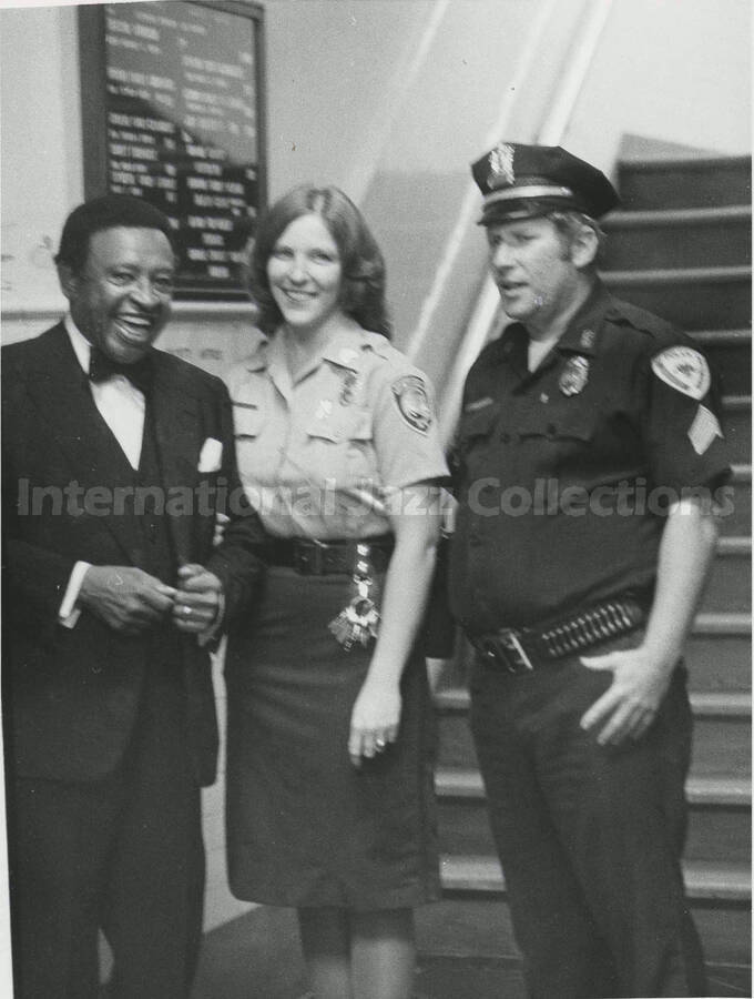 8 1/2 x 6 1/2 inch photograph. Lionel Hampton stands with two unidentified police personnel