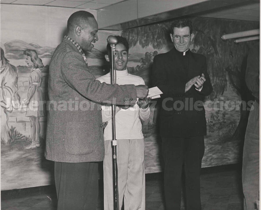 8 x 10 inch photograph. Lionel Hampton with unidentified boy and religious person