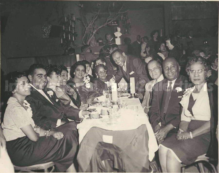 8 x 10 inch photograph. Lionel Hampton with unidentified persons in a restaurant