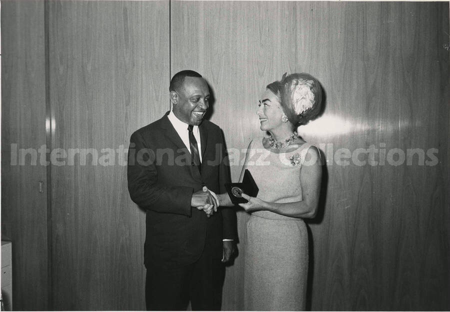 8 x 10 inch photograph. Lionel Hampton with Joan Crawford. She is holding a medal from Playboy