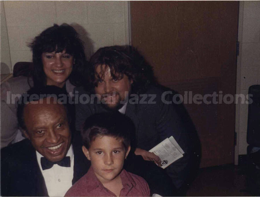 3 3/4 x 5 inch photograph. Lionel Hampton with a family. Handwritten on the back of the photograph: Derek Haynes; parents Gary and Lori; Warren, Michigan