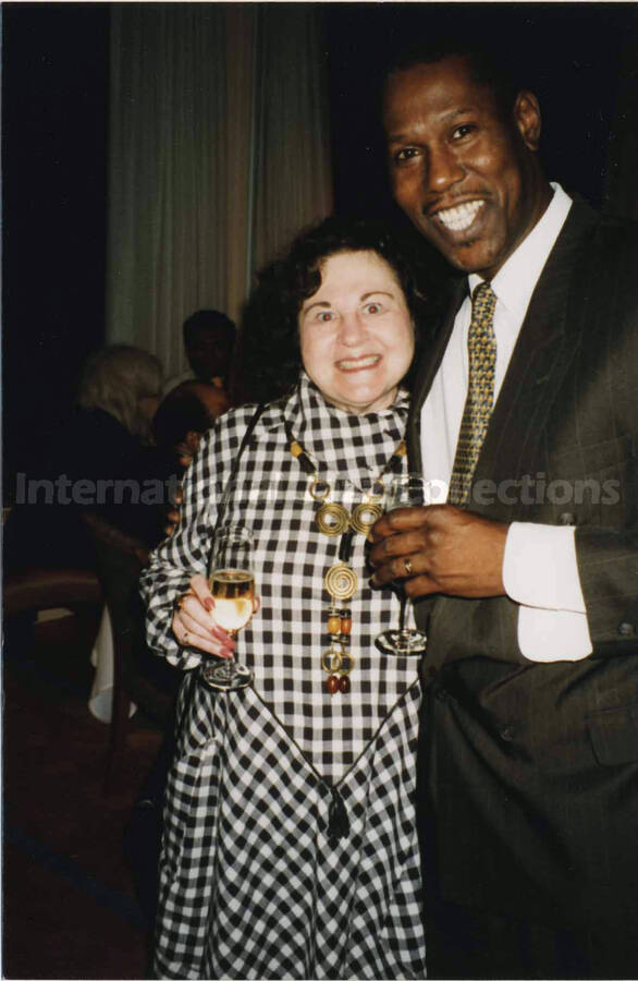 6 x 4 inch photograph. Reuben, Lionel Hampton's valet, and an unidentified woman at a reception.