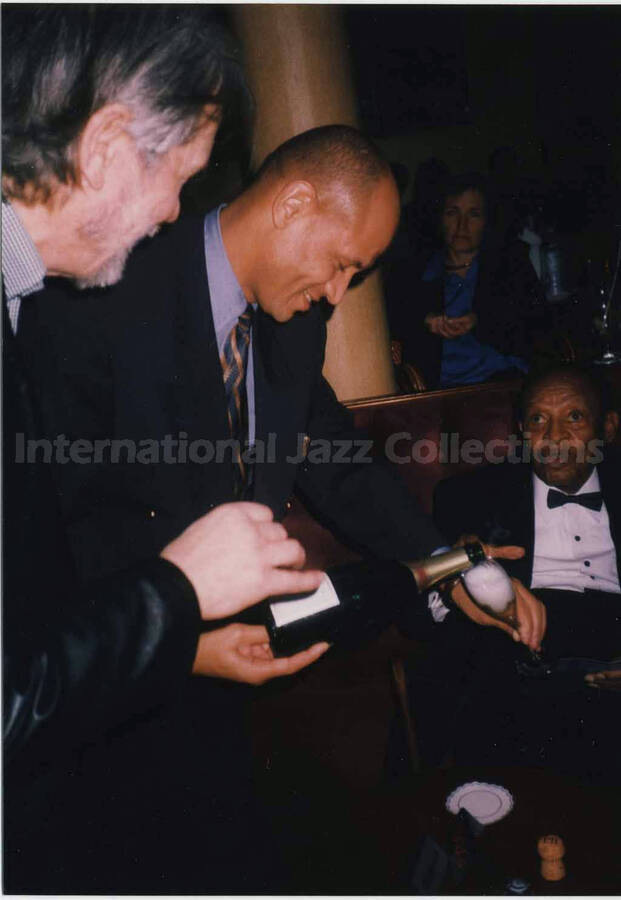 5 x 3 1/2 inch photograph. unidentified man pours Lionel Hampton a glass of champagne