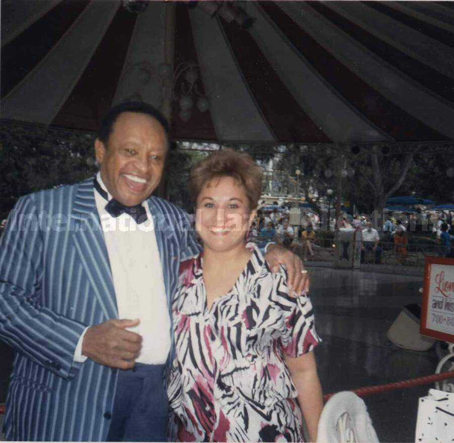 4 x 4 inch photograph. Lionel Hampton with a fan at Disneyland. This photograph has a dedication on the back, from Amalia