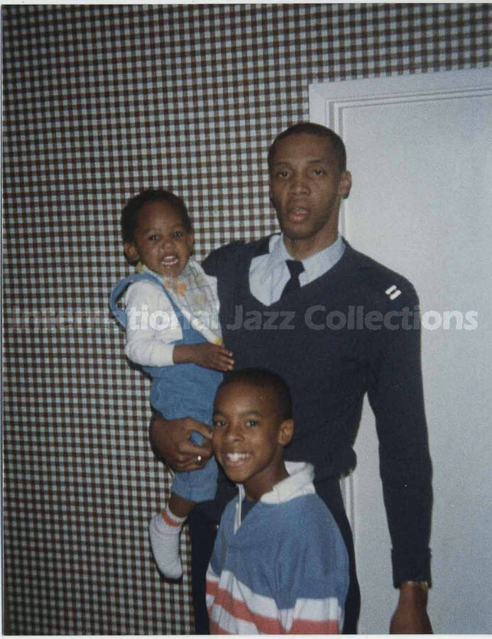 4 1/2 x 3 1/2 inch photograph. Three unidentified persons: a military man and his two children