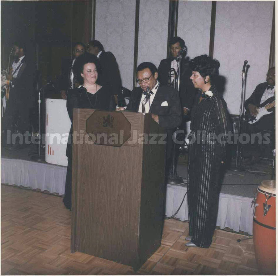 3 1/2 x 3 1/2 inch photograph. Lionel Hampton with [Pat Williams] and an unidentified woman, in a ceremony at the Garden City Hotel