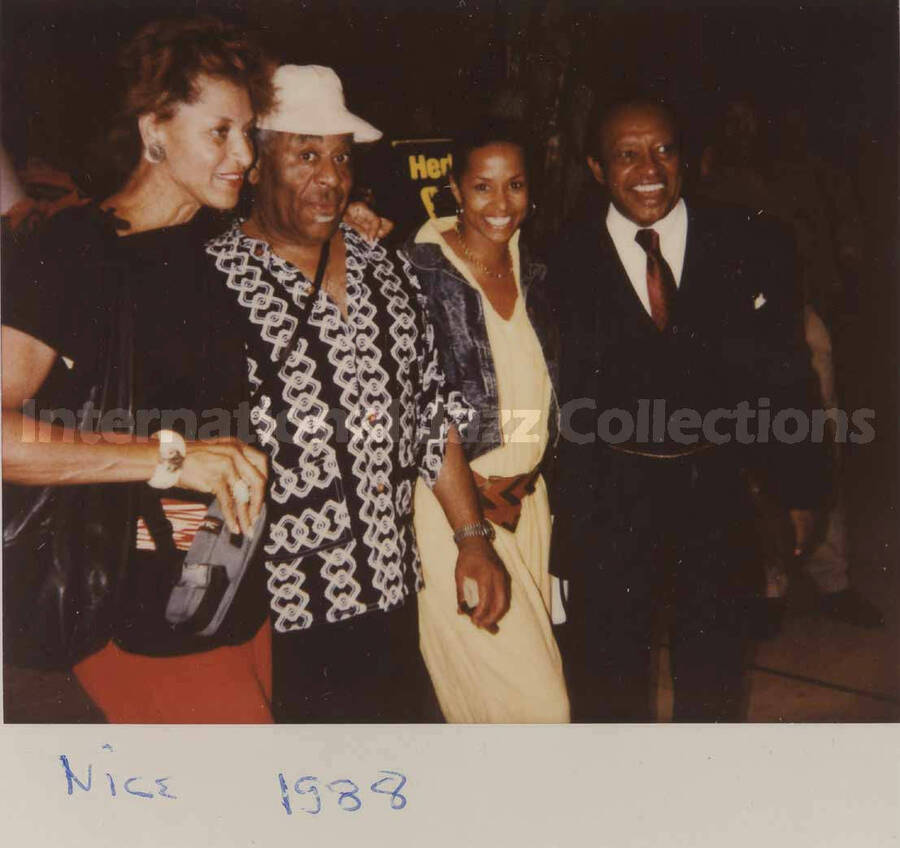 4 x 4 inch photograph. Lionel Hampton, Dizzy Gillespie, and unidentified women in Nice, France