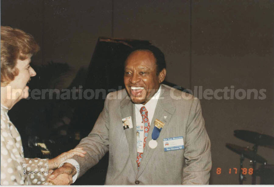 4 x 6 inch photograph. Lionel Hampton shakes hands with unidentified woman, on the occasion of the Republican National Convention, in New Orleans, LA